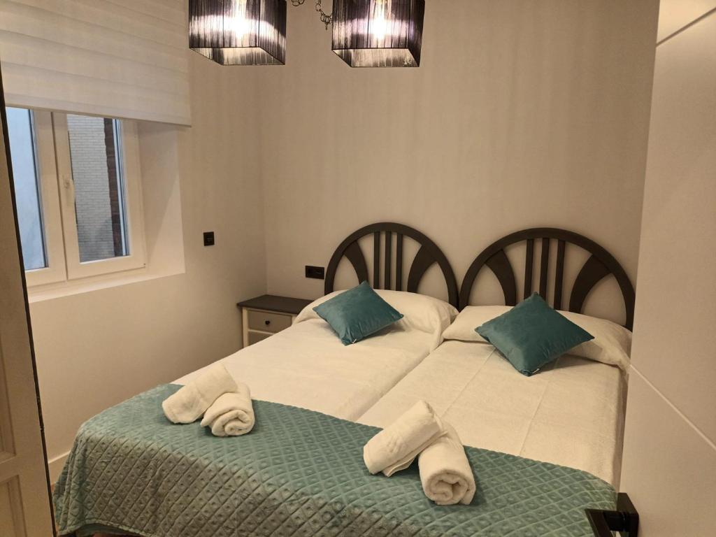 a bedroom with two beds with towels on them at Apartamento Roma 8 in León