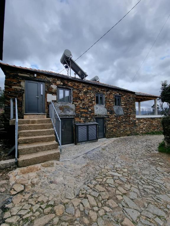 a stone house with a stone driveway in front of it at Casa de baixo studios in Arouca