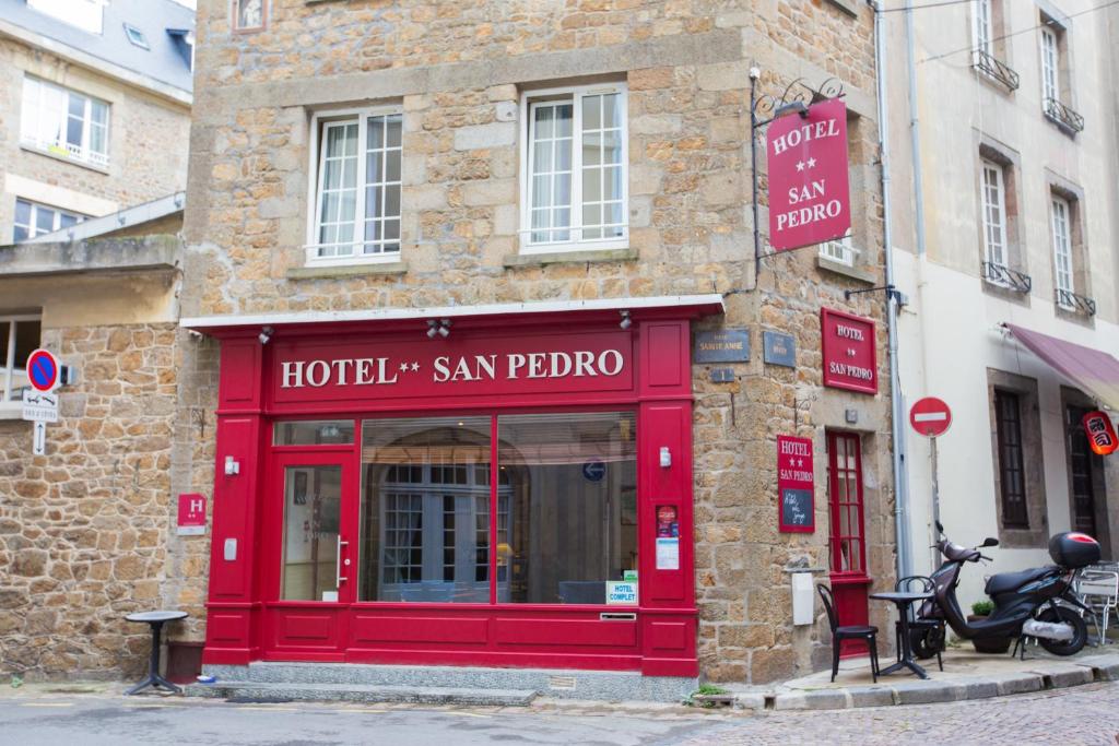 uma loja vermelha de um hotel San Pedro numa rua em Hôtel San Pedro em Saint Malo