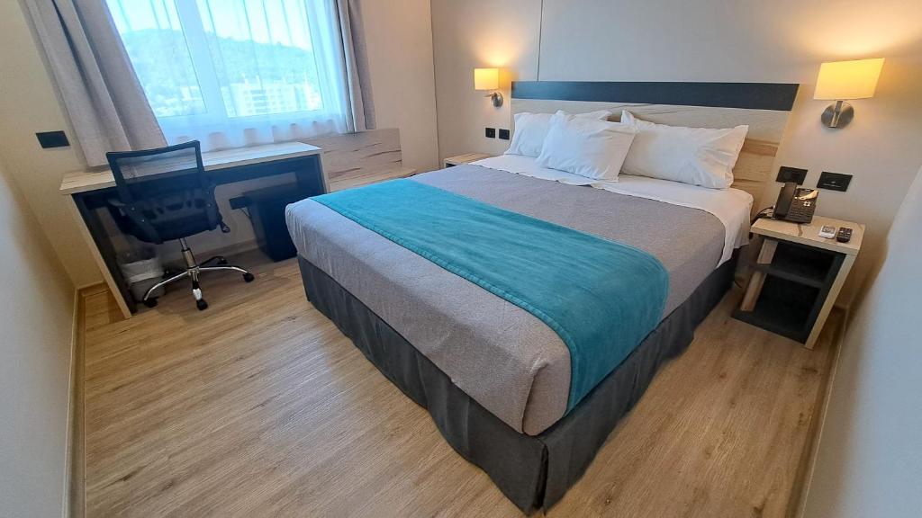 1 dormitorio con 1 cama grande, escritorio y ordenador en Hotel Diego de Almagro Temuco Express, en Temuco