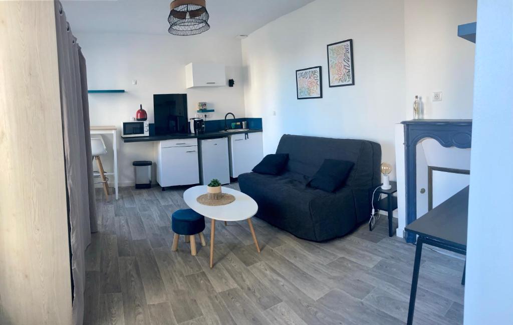 ein Wohnzimmer mit einem Sofa und einem Tisch in der Unterkunft 99 BIS FP in Limoges