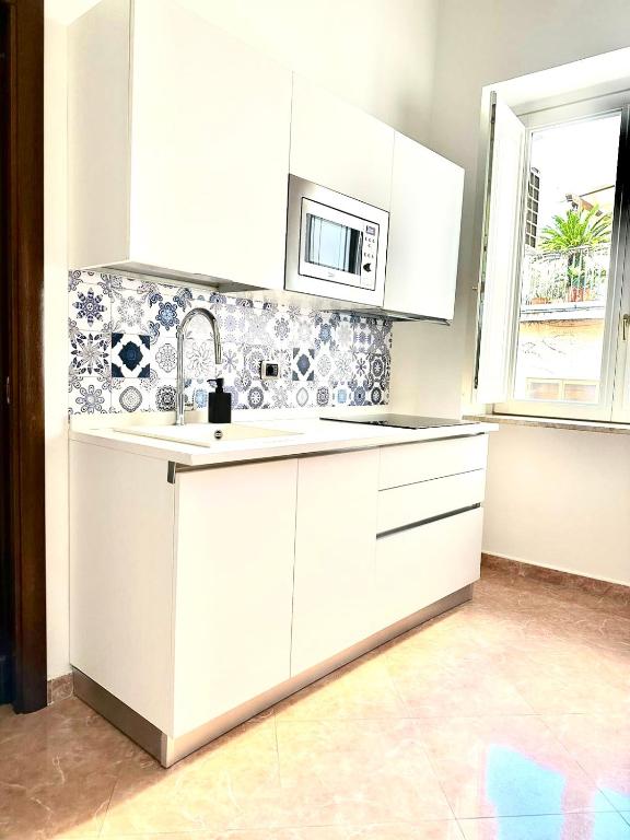 a white kitchen with a sink and a microwave at Casa Portanova 35 in Salerno