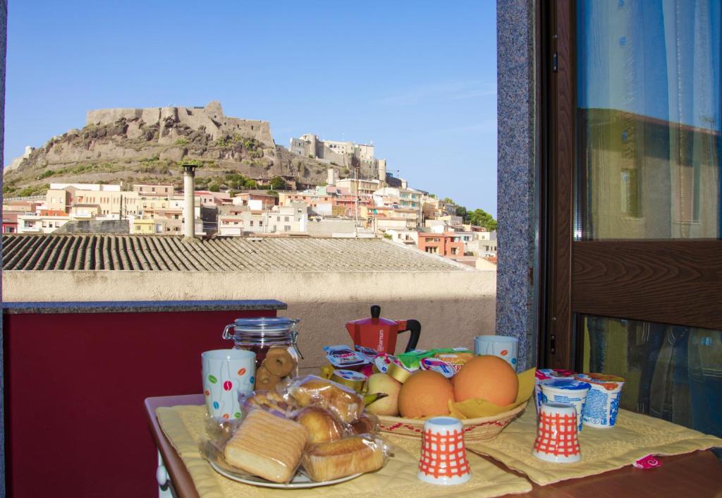 a table with a plate of food with a view of a mountain at B&B Nonna Sini in Castelsardo