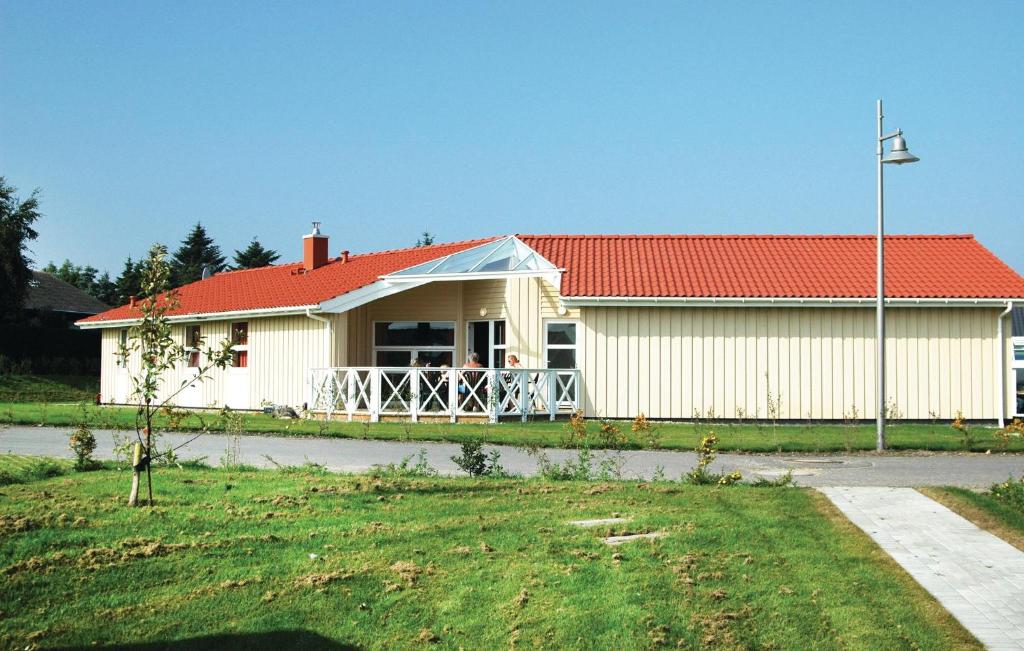 ein weißes Haus mit einem roten Dach und einem Hof in der Unterkunft Strandblick 36 in Schönhagen
