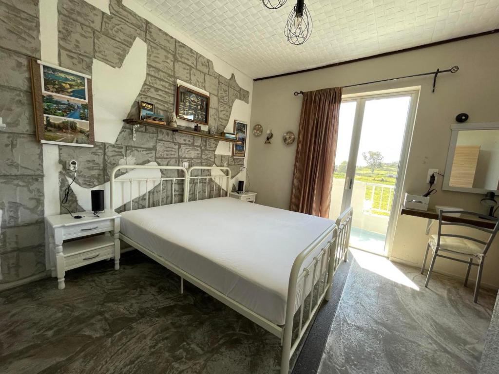 a bedroom with a bed and a stone wall at Efi studios in Kardamaina