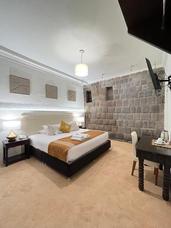 um quarto com uma cama king-size e uma secretária em Katari at Plaza de Armas Cusco em Cusco