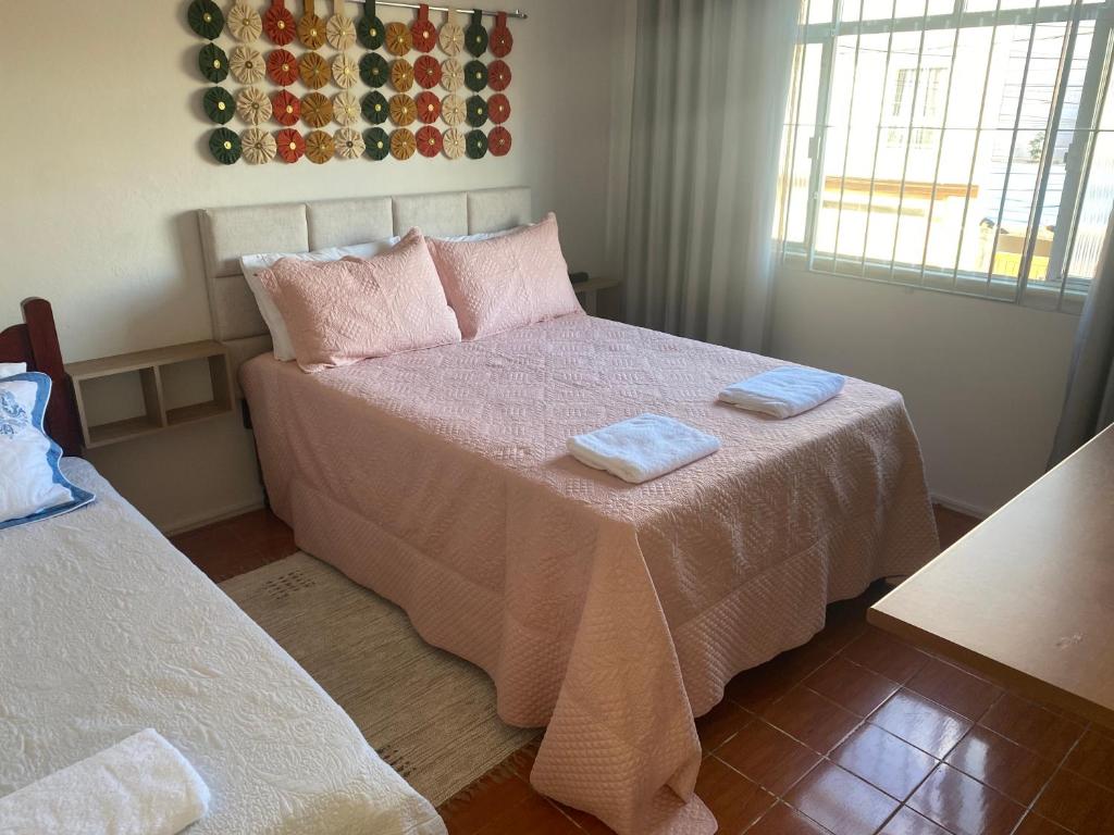 1 dormitorio con 1 cama con 2 toallas en Pousada Apartamento loft Braga, en Cabo Frío