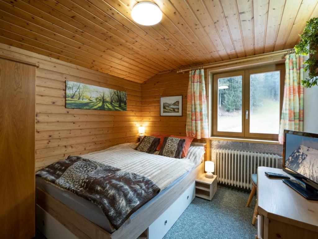 ein Schlafzimmer mit einem Bett in einer Holzhütte in der Unterkunft Haus Spertental in Kirchberg in Tirol