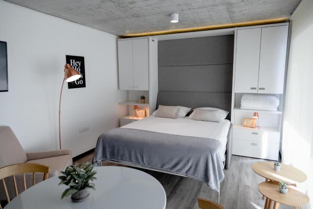 een kleine slaapkamer met een bed en twee tafels bij Prime Suites in Antofagasta