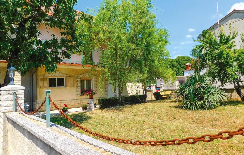 a house with a chain in front of a yard at Nice Apartment In Marcana With Wifi in Marčana
