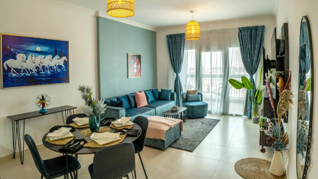 - un salon avec un canapé bleu et une table dans l'établissement Your 1BR Retreat on Yas Island Blue Sapphire Apartment, à Abu Dhabi