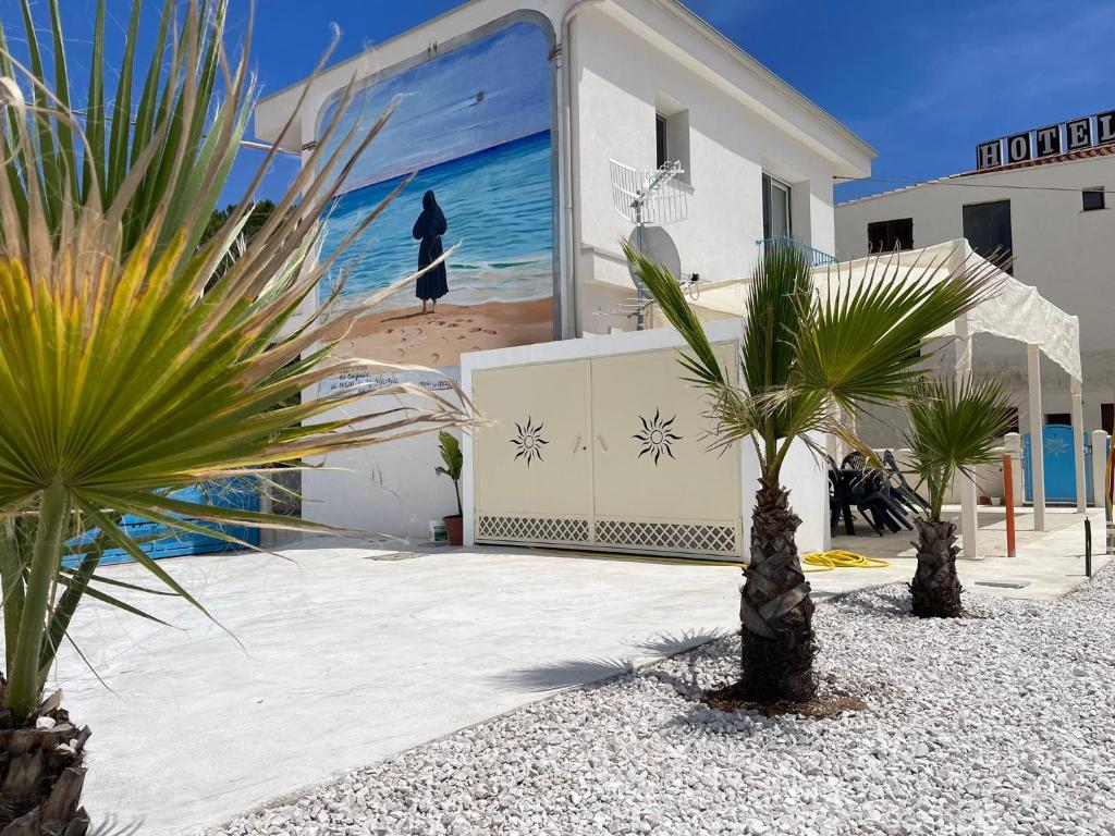 ein Gebäude mit einem Wandbild einer Frau am Strand in der Unterkunft Villa Rosa in Bari Sardo
