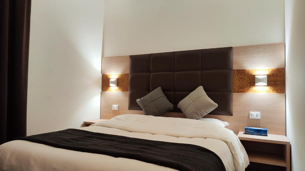 a bedroom with a large bed with two lights on it at Hotel 999 in Prato