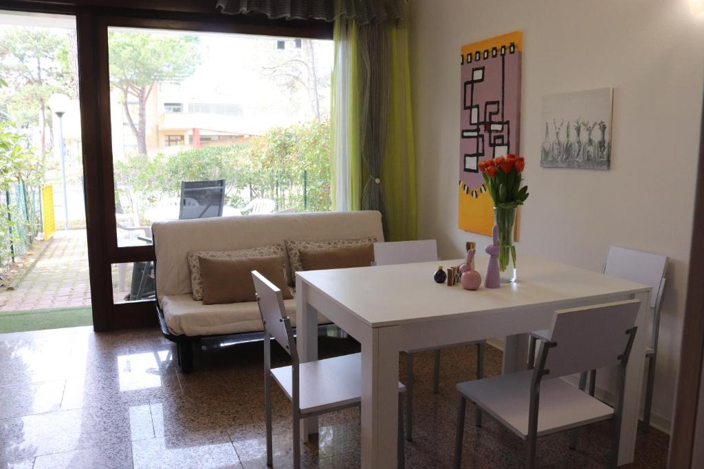 sala de estar con mesa, sillas y sofá en Beach House Riviera en Lignano Sabbiadoro