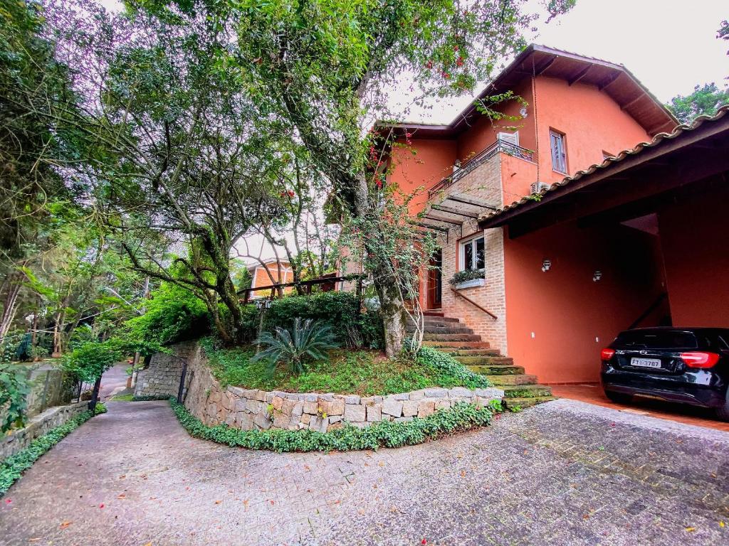 a house with a car parked in front of it at Piscina aquecida, lareira e vista cinematográfica in Carapicuíba