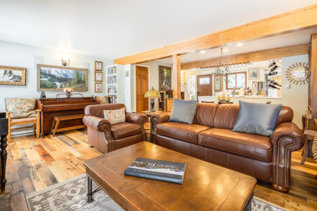 a living room with leather furniture and a piano at Camp Cottonwood in Teton Village