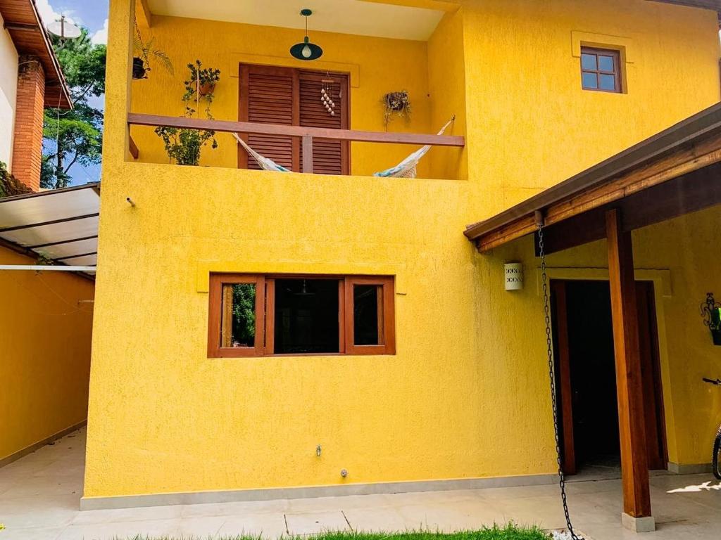 uma fachada amarela de uma casa com uma janela em Espaço gourmet e home-office na Granja em São Paulo