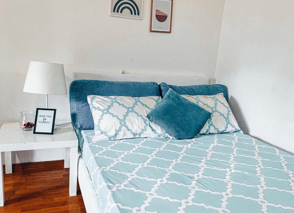 Bett mit blauer Decke und einem weißen Tisch in der Unterkunft He-Ra apartment 6 with Free Netflix in Skopje