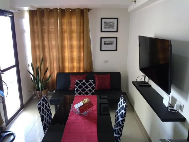 uma sala de estar com um sofá e uma televisão de ecrã plano em Mabolo Garden Flats em Cebu