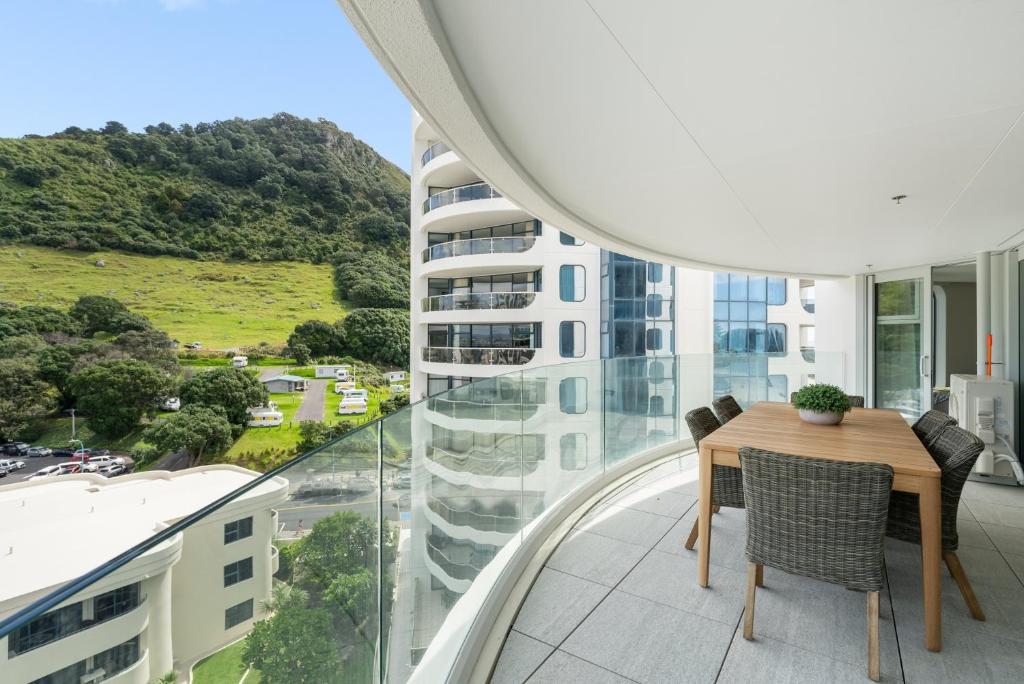 a balcony with a table and chairs on a building at Executive Oceanside Apartment in Mount Maunganui