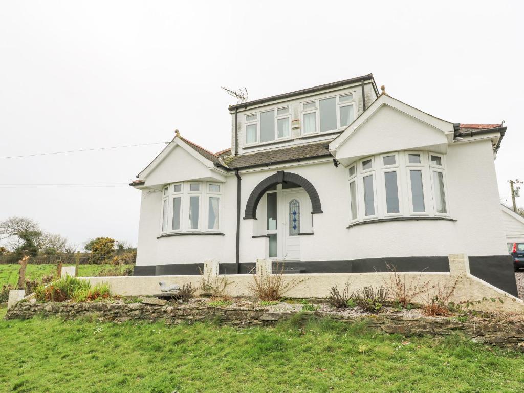 a white house on a grassy hill at Trelydarth in St. Agnes 