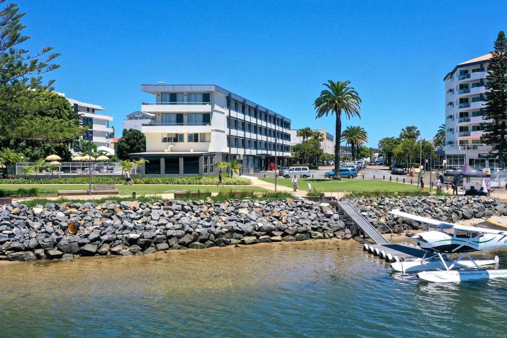 a marina with boats in the water in front of a building at The Mid Pacific in Port Macquarie