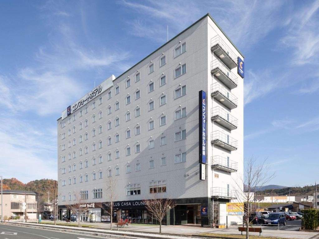 a large white building on the corner of a street at Comfort Hotel Hikone in Hikone