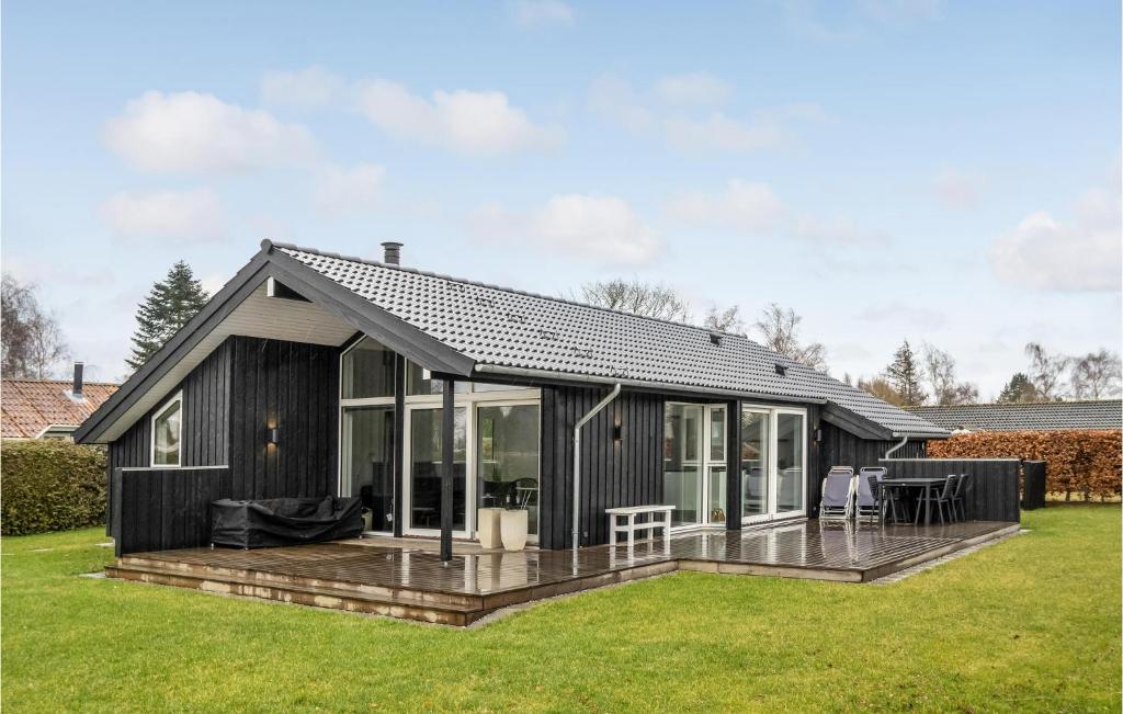 una casa negra con terraza en un patio en Amazing Home In Stubbekbing With Wifi, en Stubbekøbing