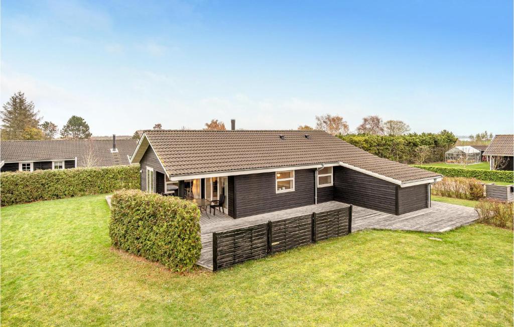 ein schwarzes Haus mit einer Terrasse im Hof in der Unterkunft Cozy Home In Bog By With Sauna in Bogø By
