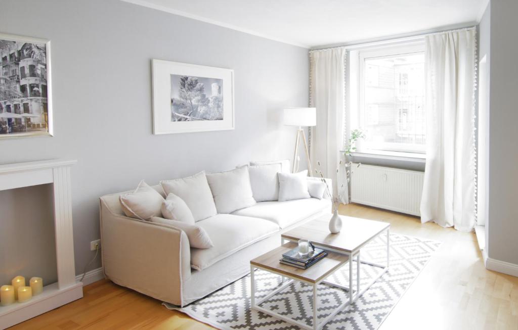 a white living room with a white couch and a table at Mediterrane Wohnung nahe HBF mit Domblick in Bremen