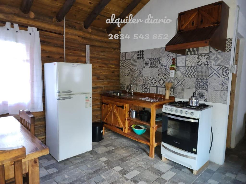 波特雷里約斯的住宿－La margarita，厨房配有白色冰箱和炉灶。