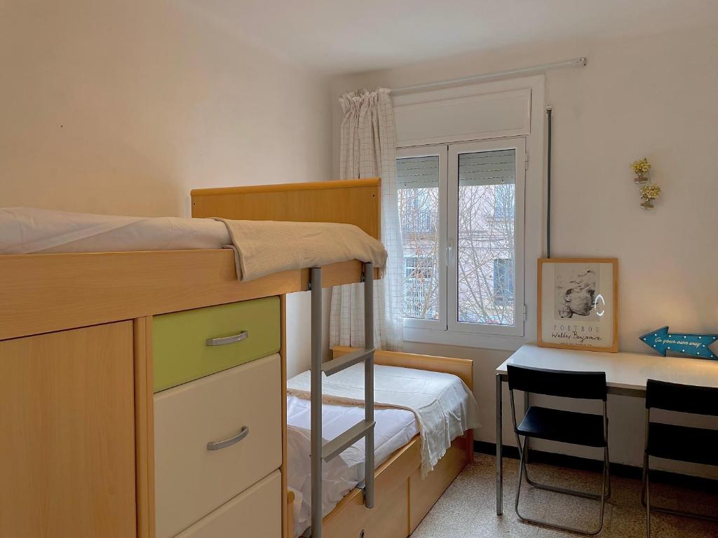a small bedroom with a bunk bed and a desk at Apartamento estación de Portbou in Portbou