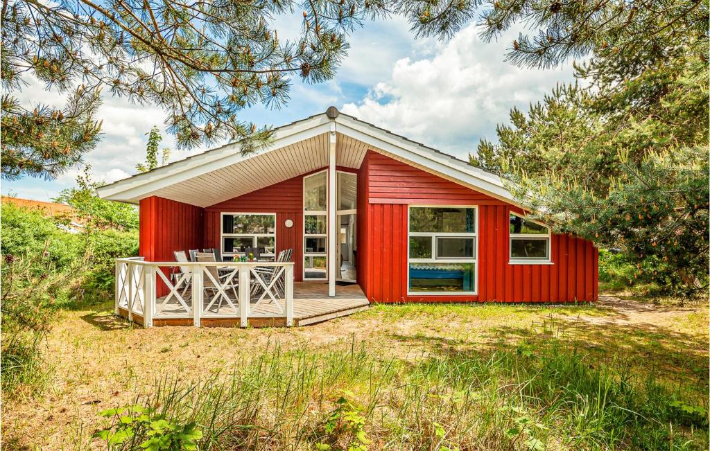 een rood tiny house met een terras in een yard bij Strandblick 1 - Dorf 1 in Travemünde