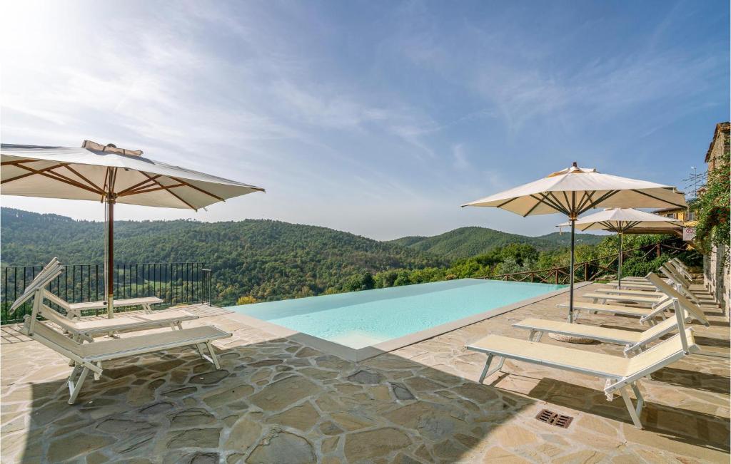 - une piscine avec 2 parasols et 2 chaises longues dans l'établissement Casale Valle Di Sopra, à Anghiari