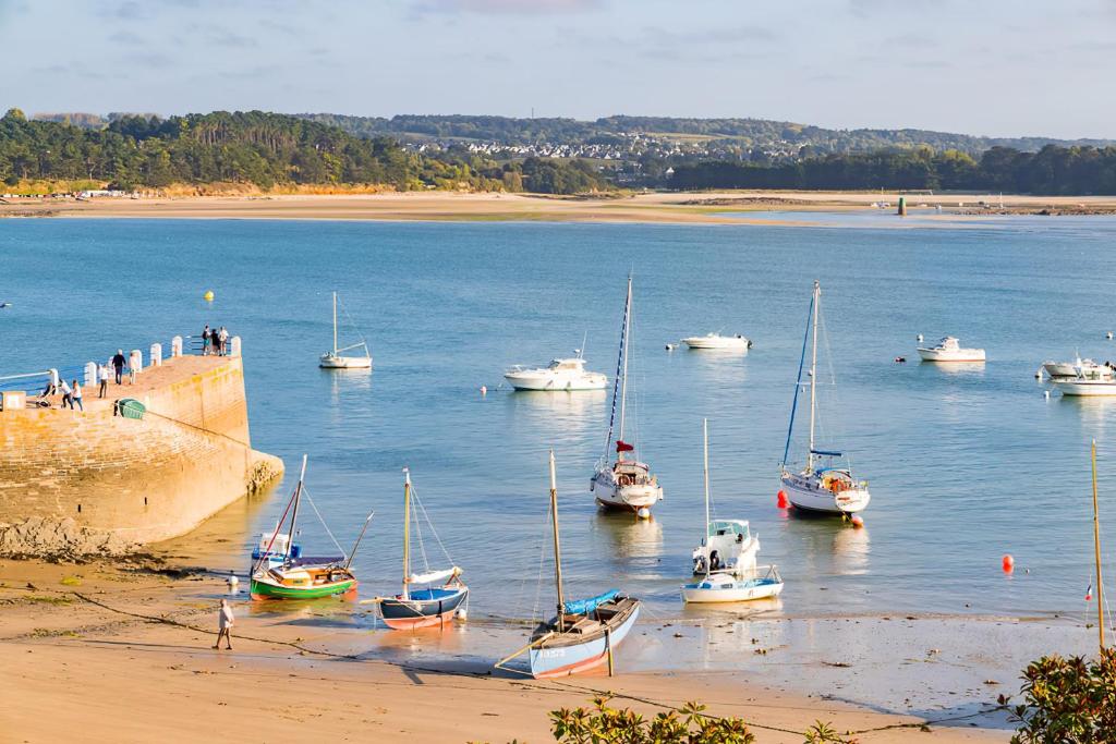 a group of boats in the water near a beach at Villa Saint Kirio - piscine et spa in Morlaix