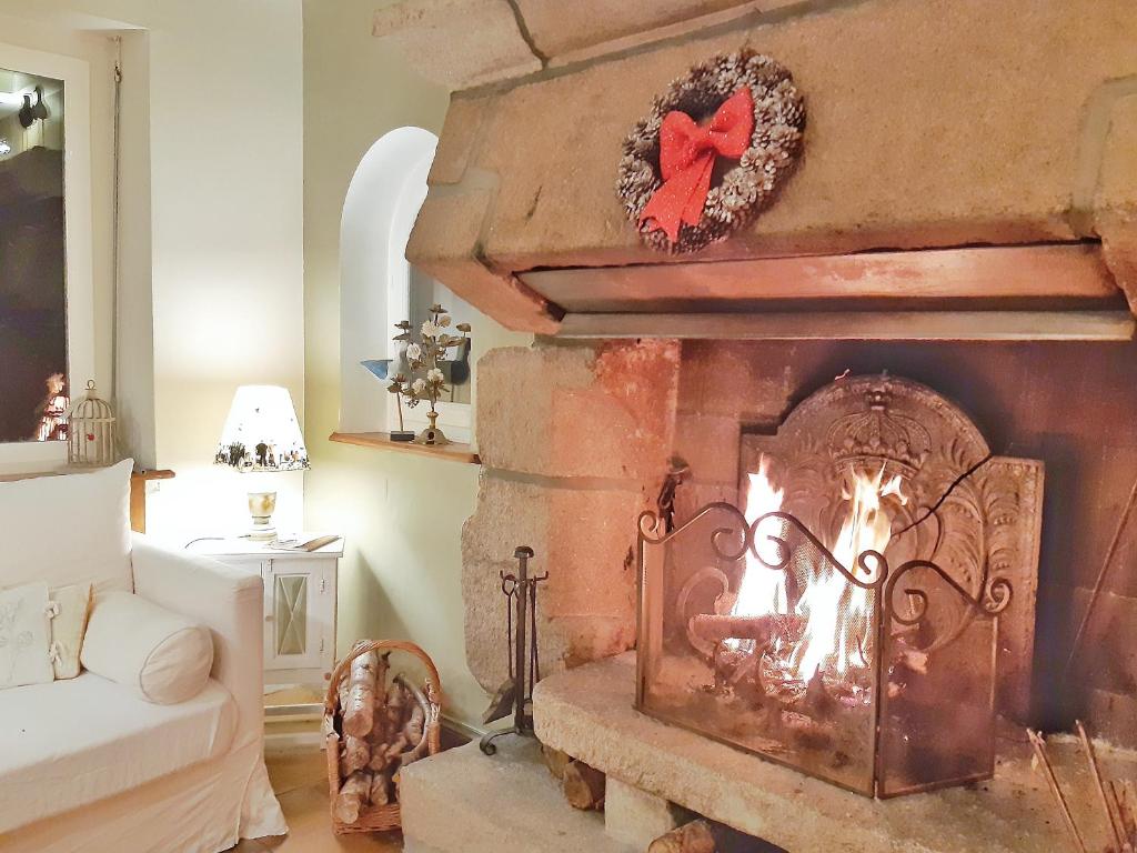 a living room with a fireplace with a red bow on it at Villa Saint Kirio - piscine et spa in Morlaix