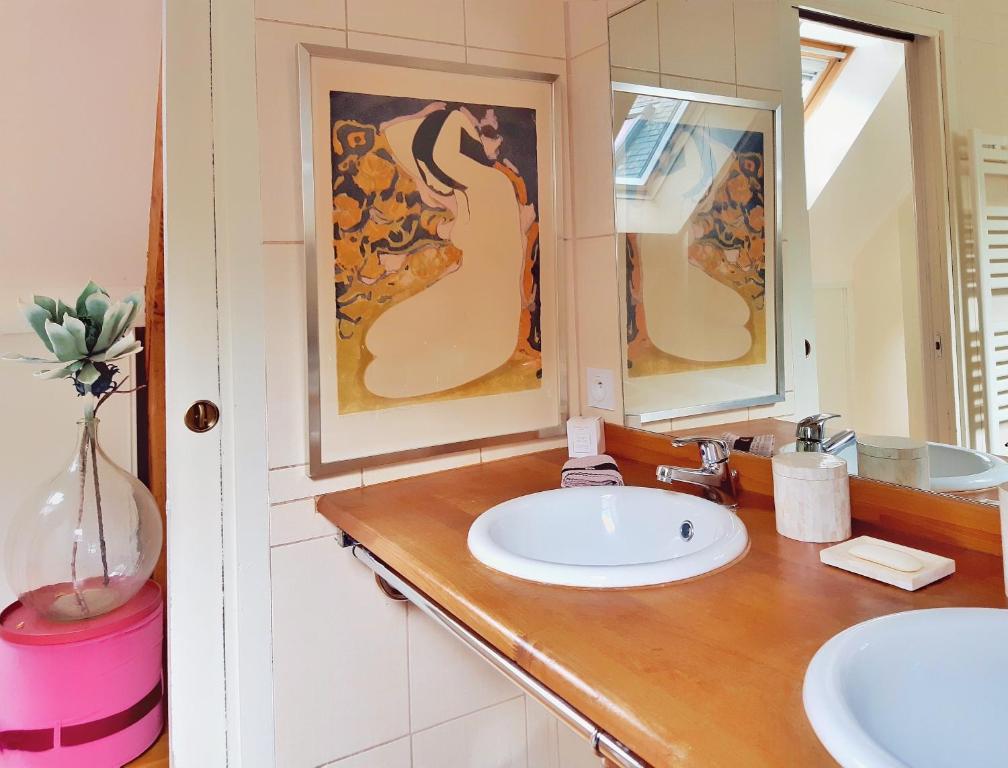 a bathroom with a sink and two mirrors at Villa Saint Kirio - piscine et spa in Morlaix