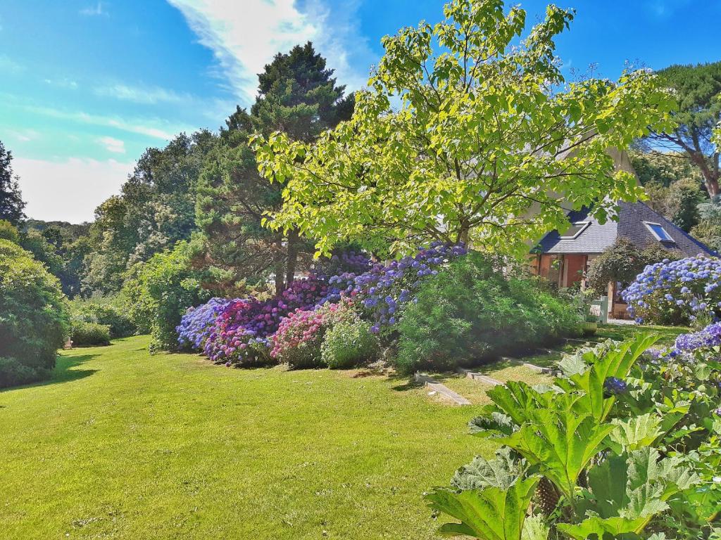 a garden with colorful flowers and a house at Villa Saint Kirio - piscine et spa in Morlaix