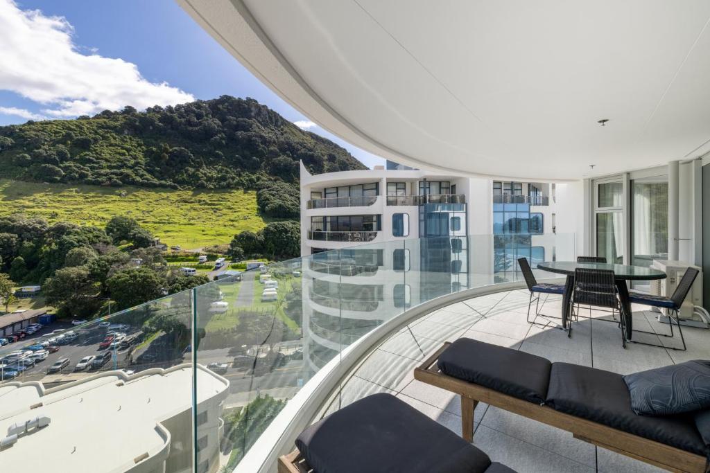 - un balcon avec une table et des chaises dans un bâtiment dans l'établissement Oceanside Apartment with Iconic Views, à Mount Maunganui
