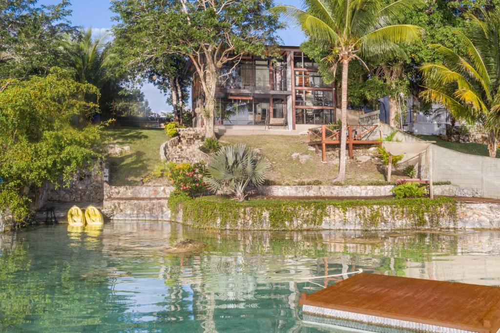 "casa Villa Real, A Gem On The Shores Of Bacalar" في باكالار: بيت فيه مسبح قدام بيت