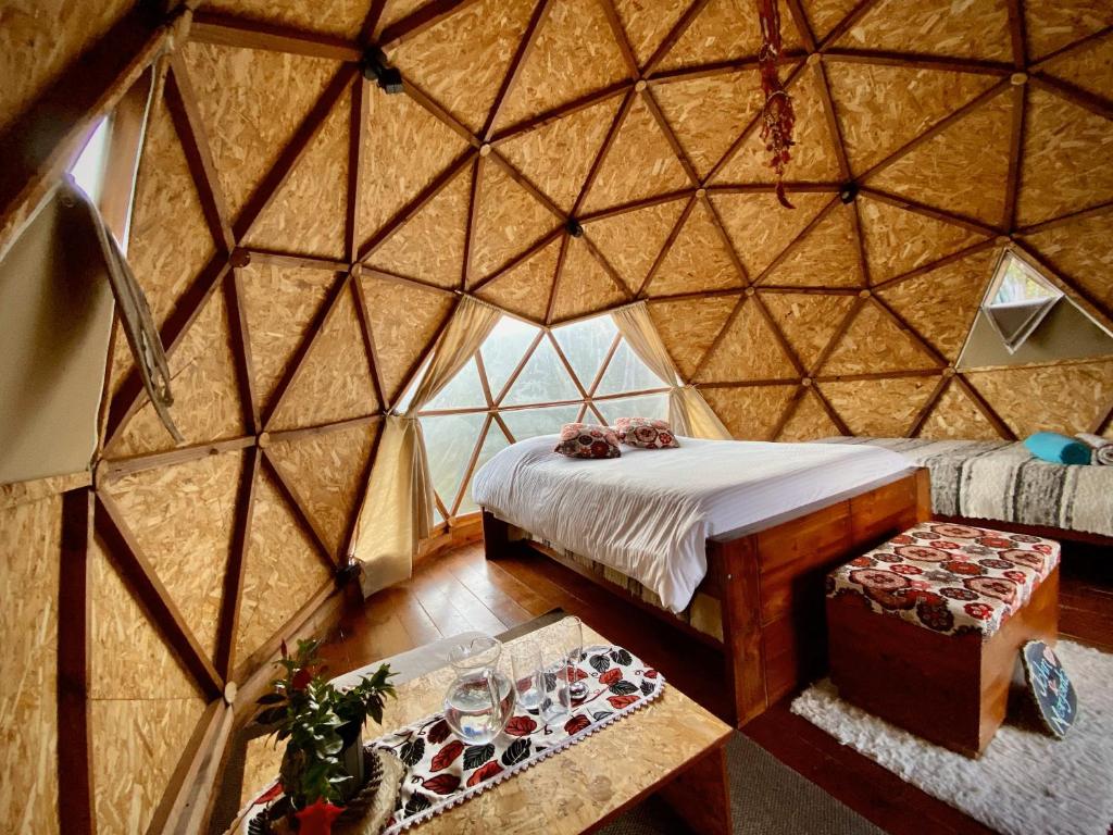 a room with a bed and a table in a yurt at Aldebarán Farming & Glamping in Duitama