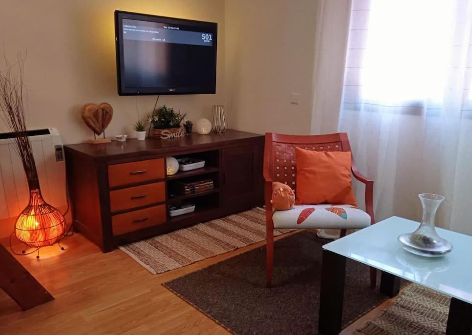 a living room with a tv and a chair at Acogedor Apartamento Ocaña in Ocaña