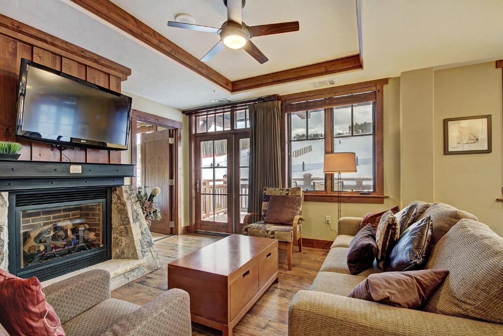 a living room with a fireplace and a flat screen tv at One Ski Hill Place S8309 in Breckenridge