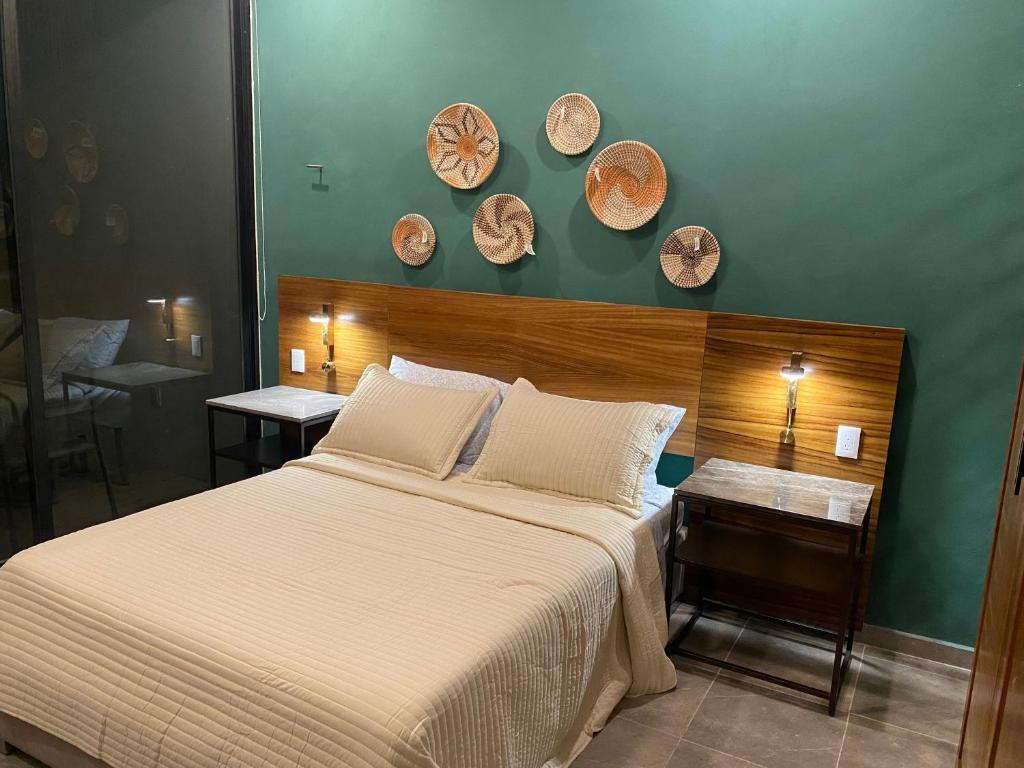 um quarto com uma cama e duas mesas com placas na parede em Via 31 Departamentos Valladolid em Valladolid