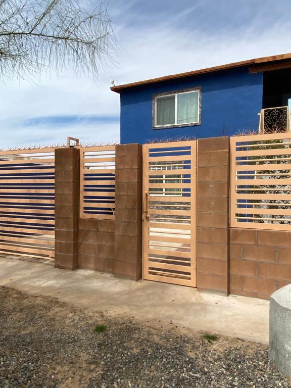 une clôture avec volets en bois devant une maison bleue dans l'établissement Large 4 bedroom home with gated parking, à Puerto Peñasco