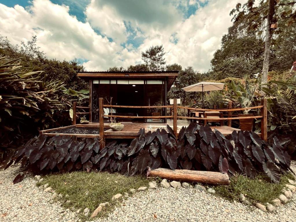 a house with a log fence and an umbrella at Glamping Salento in Salento