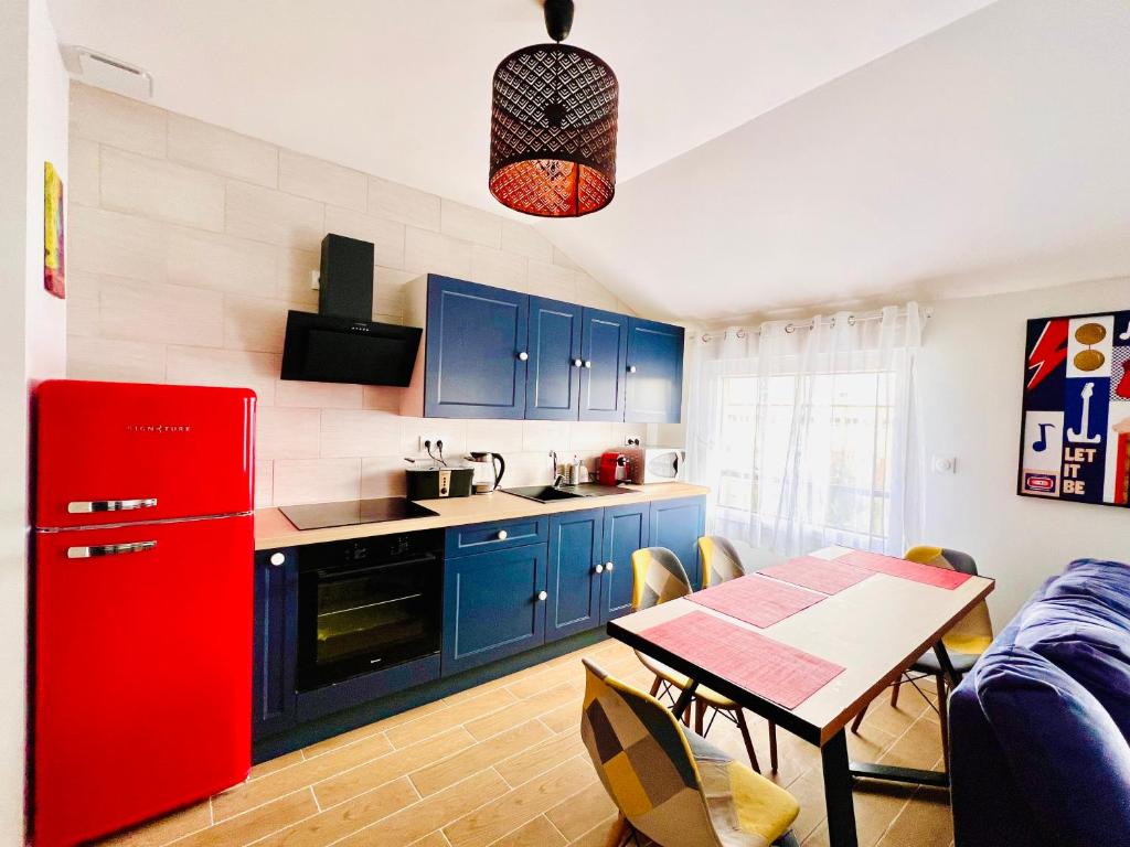 a kitchen with blue cabinets and a red refrigerator at Merveilleux T2 en hypercentre in Châlons-en-Champagne