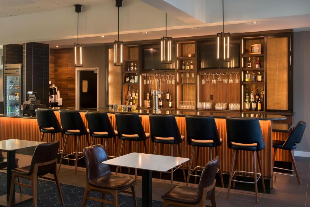 a bar with a row of chairs and tables at Courtyard By Marriott Baltimore Hunt Valley in Hunt Valley