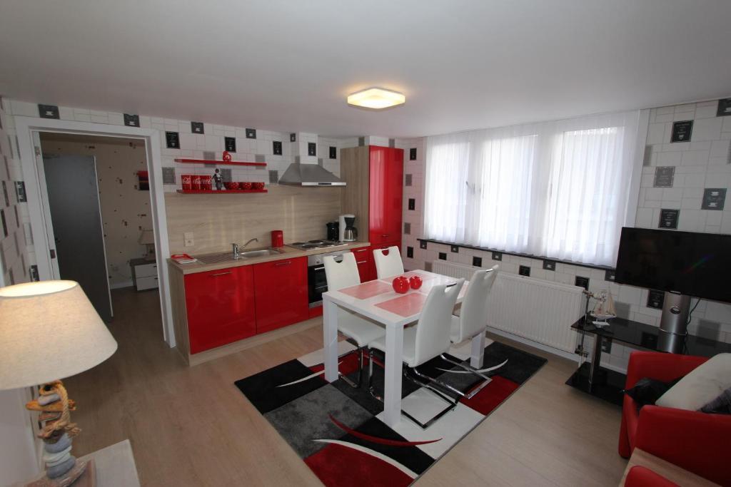 a kitchen with a white table and red cabinets at Skyline in Ieper