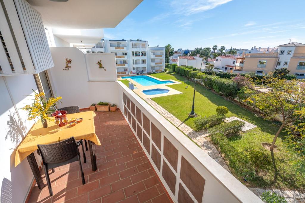 einen Balkon mit einem Tisch und einem Pool in der Unterkunft AlgarSun - idealy situated holiday apartment with all modern comfort in Albufeira